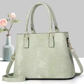 Détail du sac à main vert clair à texture tissée avec boucle dorée et bandoulière - Vert