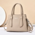 Close-up of beige lychee grain leather handbag with silver hardware and dual handles - Light Khaki