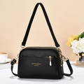 Macro shot of black lychee grain leather crossbody bag with premium gold zipper detail - Black