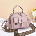 Pink pebbled leather handbag with ethnic woven strap and decorative front pockets - Pink