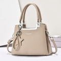 Detail of beige lychee pattern tote bag with silver hardware and star pendant accessory - Light Khaki