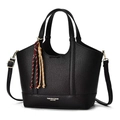 Détail d'un sac seau en cuir grainé noir avec poignées et breloque à pompon coloré - Noir