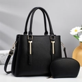 Detail of black pebbled leather handbag set with gold hardware and a matching pouch - Black