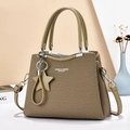 Olive green woven crossbody bag with leather handles and star charm on geometric background - Green