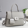 Elegant grey square handbag with diamond G logo and quilted details on white background - Gray