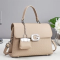 Detail of beige litchi leather bag with G-logo and mini Kelly-style charm accessory - Apricot