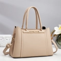 Elegant beige pebbled leather handbag with gold metal bar and adjustable shoulder strap - Apricot