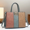 Detailaufnahme der dreifarbigen Ledertasche mit goldener B-Schnalle und zwei Griffen - Grün