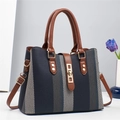 Dettaglio borsa in tessuto a righe blu con manici in pelle marrone e minuterie dorate - Nero
