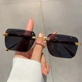 Primer plano de gafas de sol cuadradas sin montura de lujo con patillas de metal dorado - Gris Negro