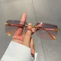Detalle de gafas de sol cuadradas al aire con lentes degradadas y textura madera - Gris Rosa