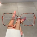 Close-up of square vintage glasses featuring amber tortoise shell and clear frames - Transparent Orange Black Edge