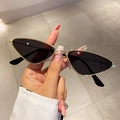 Minimalist cat-eye sunglasses with thin golden metal frames and dark lenses in hand - Gold Frame Black Grey