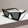 Dettaglio di occhiali da sole neri cat-eye con elegante intarsio decorativo in metallo dorato a V - Montatura Nera Lenti Grigie Decoro Oro