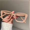 Detail view of large square milk tea colored glasses frame held against a neutral wall - Coffee Frame
