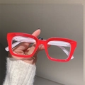 Detail of vintage square red glasses frame held by hand against a minimal background - Red Frame