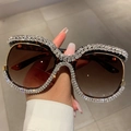 Close-up of tortoise shell oversized sunglasses featuring luxury rhinestone embellishments - Leopard Frame / Tea Lens