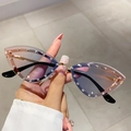 Women's cat eye sunglasses with rhinestones and gradient lenses held by hand - Blue Pink