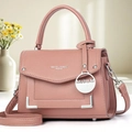 Détail d'un sac à main en cuir lilas avec des clous dorés et des éléments métalliques - Rose Poudré