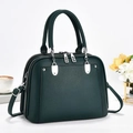 Detailed view of dark green pebbled leather tote bag with silver hardware. - Green
