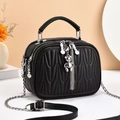 Detail of black quilted shoulder bag with silver bear charm and wavy stitch pattern - Black