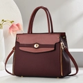 Detail view of burgundy handbag with textured fabric mix and gold twist lock closure - Wine Red