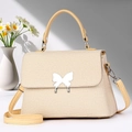 Dettaglio della borsa intrecciata beige con chiusura a farfalla argento e tracolla - Giallo Riso (Fibbia Argento)