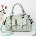 Detail of light green litchi grain leather handbag with T-buckle pockets and striped strap - Green