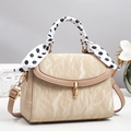 Dettaglio borsa a tracolla crema con texture plissettata, chiusura oro e foulard a pois - Cachi