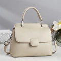 Elegant cream crossbody handbag with pebble texture and silver hardware in lifestyle setting - Apricot