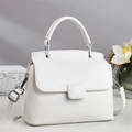 Elegant white crossbody bag with handle and top flap, shown against artistic background - White