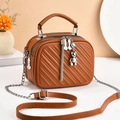 Brown quilted crossbody bag with dual zippers, top handle, and silver bear charm - Khaki/Earth Yellow