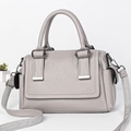 Detail view of grey pebble leather Boston bag with wide woven strap and metal hardware - Gray