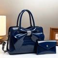 Detail der dunkelblauen Handtasche aus Lackleder mit glitzernder Strass-Schleife - Blau