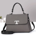 Detalle del bolso de tela gris con adornos de cuero negro y cierre de metal plateado - Negro