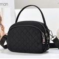 Detail of black quilted nylon crossbody bag featuring a triple zipper compartment design - Black (Gunmetal Hardware)