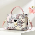 Floral paisley handbag with pink straps and gold clasp in a bright, elegant studio setting - Pink