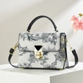 Gray paisley print handbag with golden twist lock on a minimalist display stand - Black