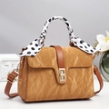 Detail of vintage brown textured handbag featuring a gold lock and polka dot scarf handle - Khaki/Earth Yellow