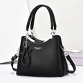 Sac à main noir grainé avec pendentif étoile et bandoulière réglable sur fond blanc épuré - 25x19x12cm / Noir