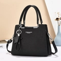 Elegante borsa da donna nera intrecciata con manici superiori e ciondolo a stella - L25 H19 P12 / Nero