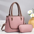Detailansicht der rosa Handtasche mit Webstruktur, braunen Riemen und goldener Hardware - Rosa