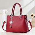 Bolso de piel roja con textura de lichi, colgante plateado y correa ajustable - Granate