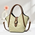 Bolso de mano verde texturizado con asas marrones y detalles dorados en escena elegante - Verde