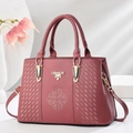 Detalle de bolso burdeos en cuero con logo dorado y patrones de bordado de diamantes - Rosa