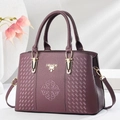 Bolso de mano morado con textura de lichi, logo dorado y detalles de bordado fino - Morado