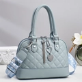 Detail of light blue quilted handbag with heart charm and woven wide shoulder strap - Blue