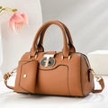 Close-up of tan Saffiano leather handbag featuring a golden geometric turn-lock and hardware - Khaki/Earth Yellow