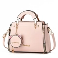 Détail d'un sac à main en cuir rose avec porte-monnaie chat et fermoir rotatif doré - Rose