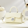 Minimalist beige crossbody bag with silver twist lock and elegant top handle shown in studio - Off-white